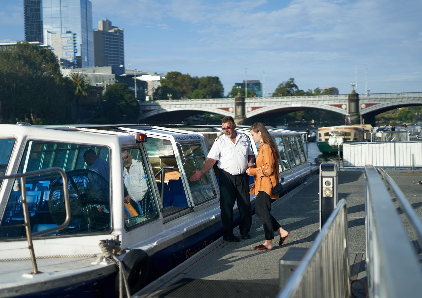 A crew member welcoming a passenger aboard the ferry at Southbank