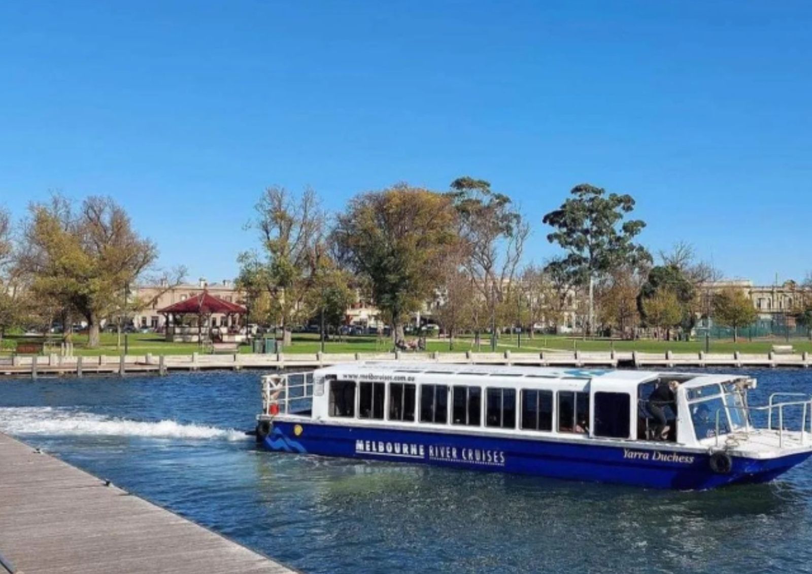The Yarra Duchess ferry cruising along the river past parkland
