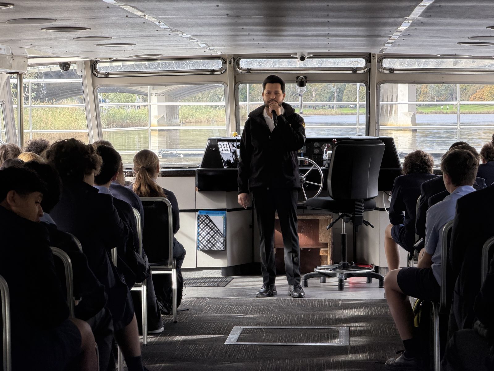 Crew member giving an onboard talk to a group of school students
